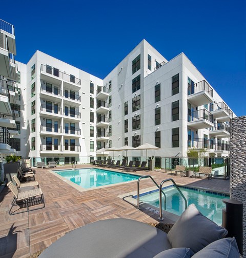 A large white building with a pool in front.