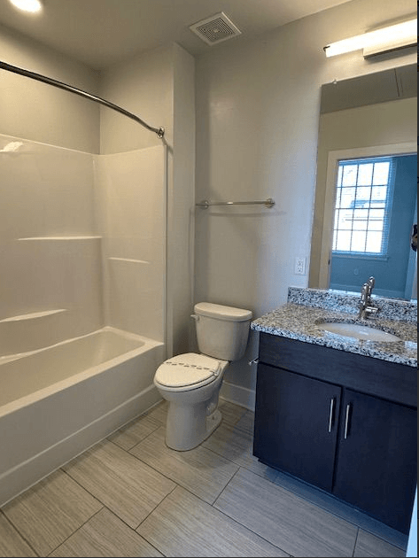 A bathroom with a toilet, sink, and bathtub.