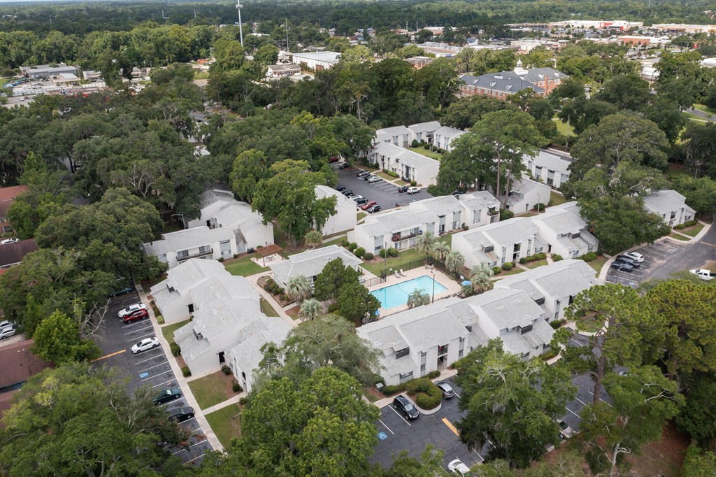 A bird's eye view of a residential area with a swimming pool.