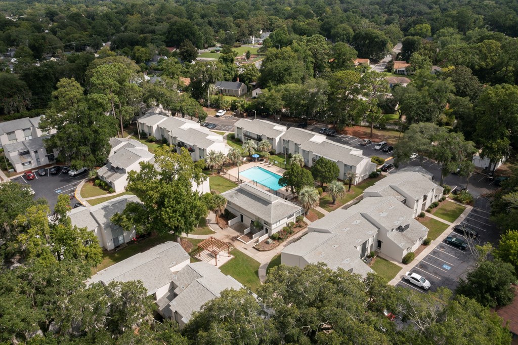 A bird's eye view of a residential complex surrounded by trees.