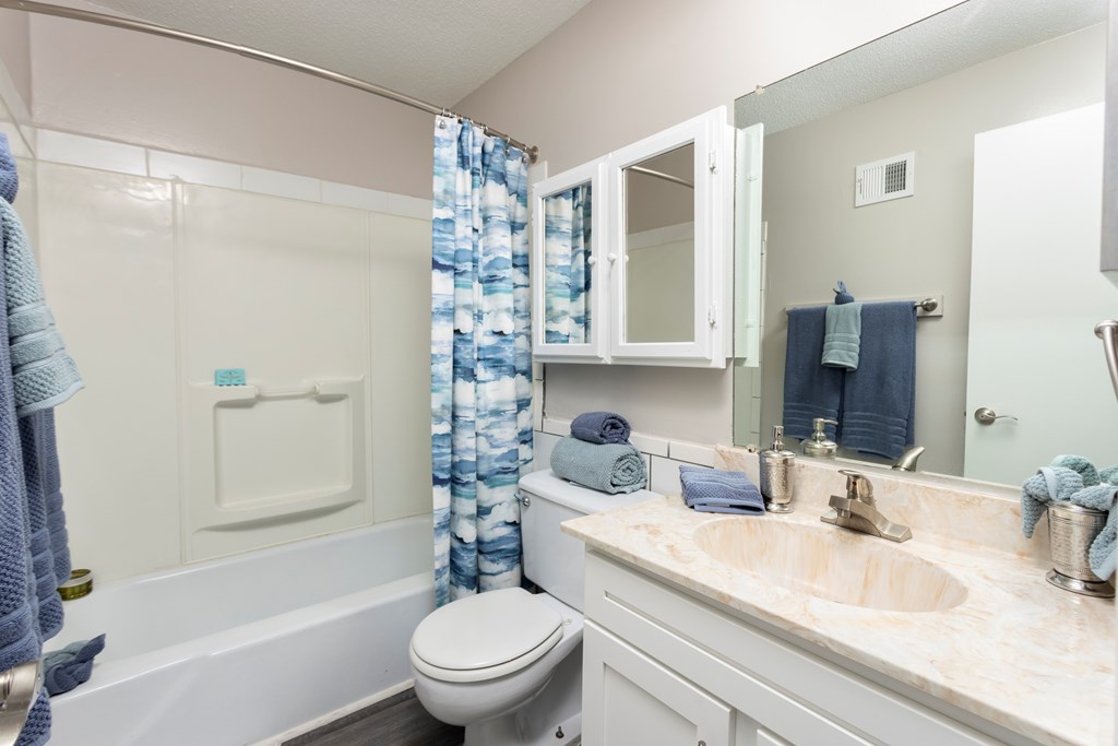 A bathroom with a toilet, sink, and shower.