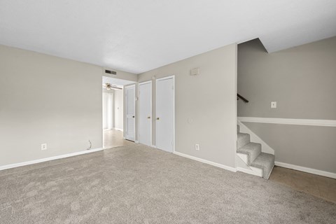A room with a staircase and two doors.