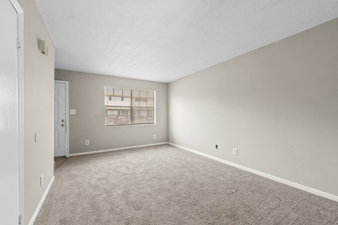 A sparsely furnished room with a window.