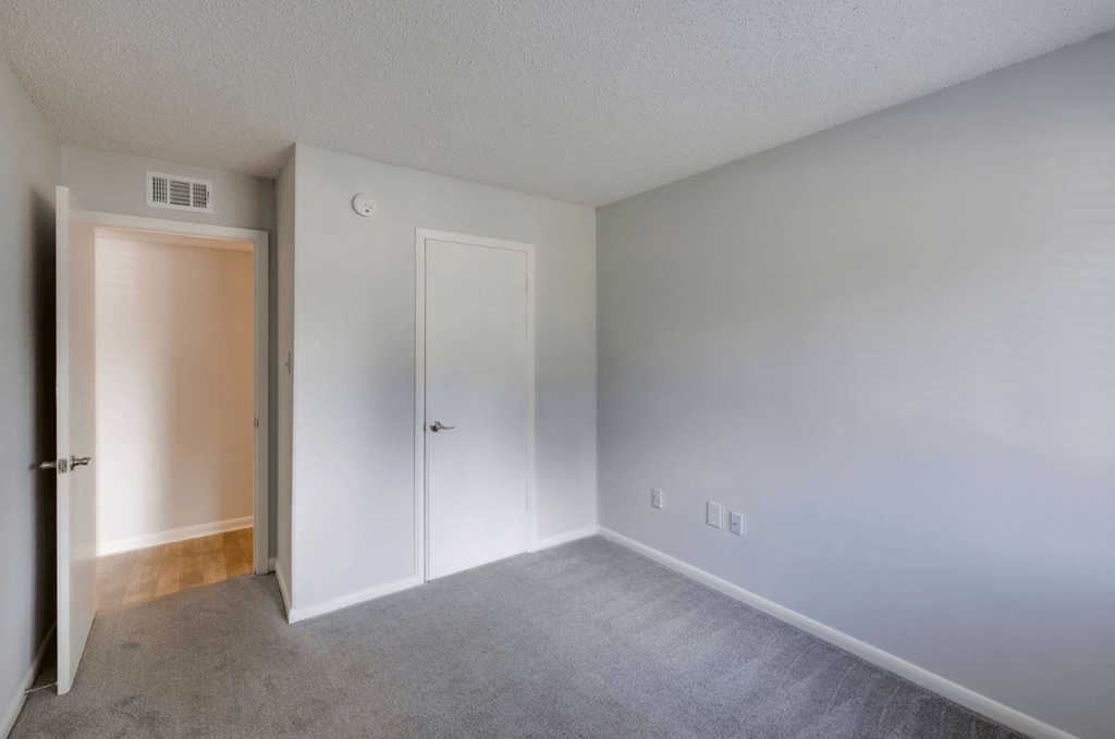 A room with a carpeted floor and two doors at Retreat at Savannah Apartments, Savannah, Georgia