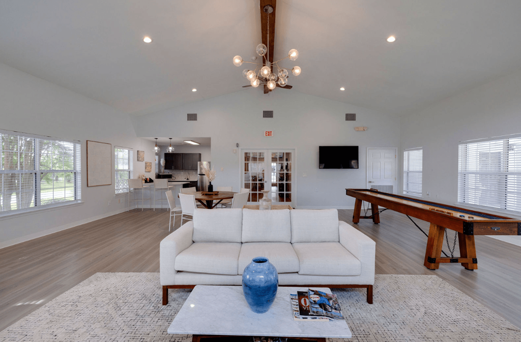 A spacious living room with a white sofa and a pool table at Retreat at Savannah Apartments, Savannah 31404