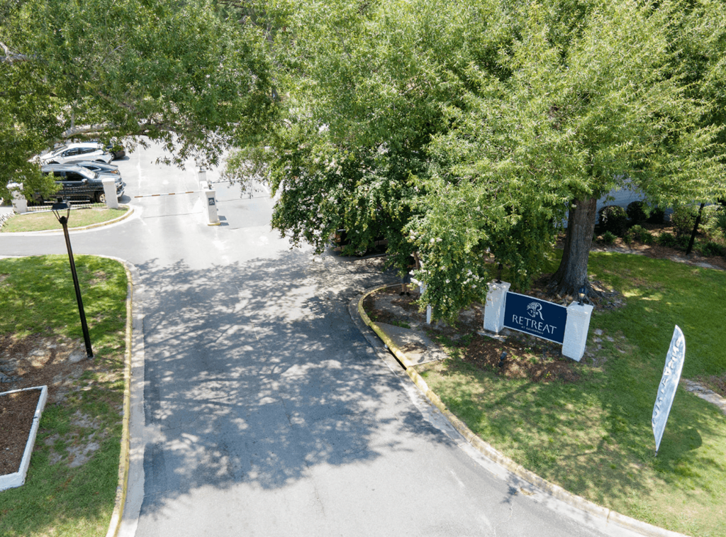 A sign that says Retreat stands in front of a tree at Retreat at Savannah Apartments, Georgia