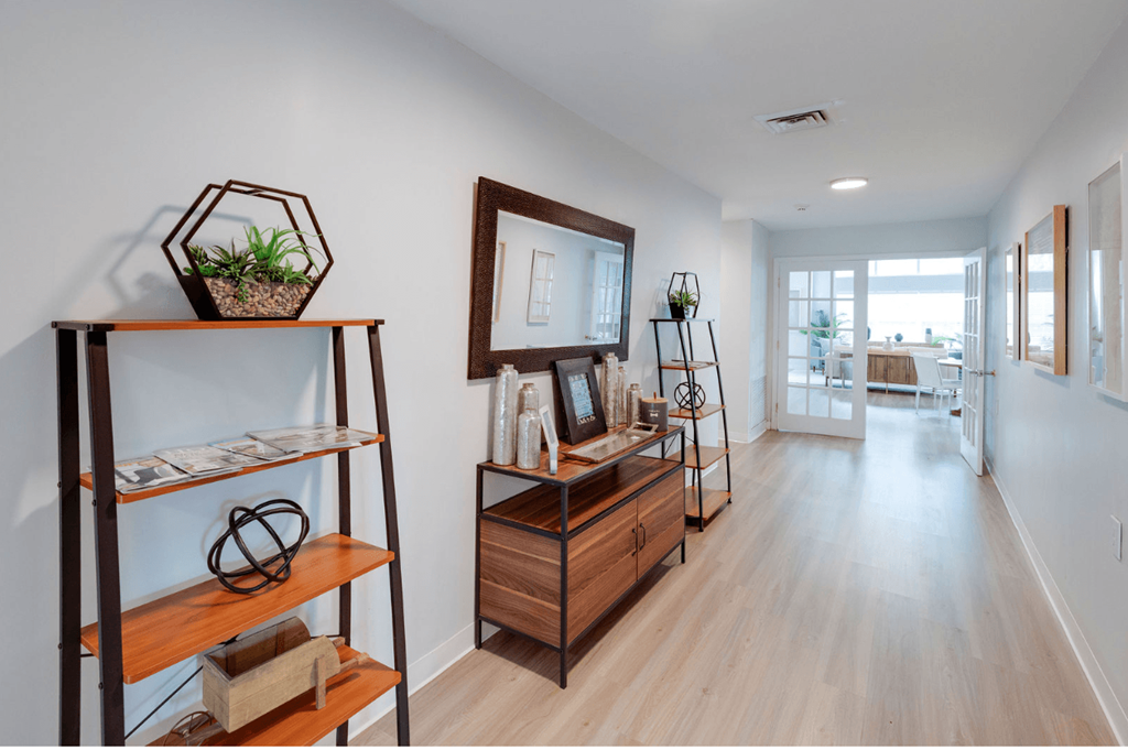 A long hallway with a wooden floor and a mirror on the wall at Retreat at Savannah Apartments, Savannah, GA, 31404