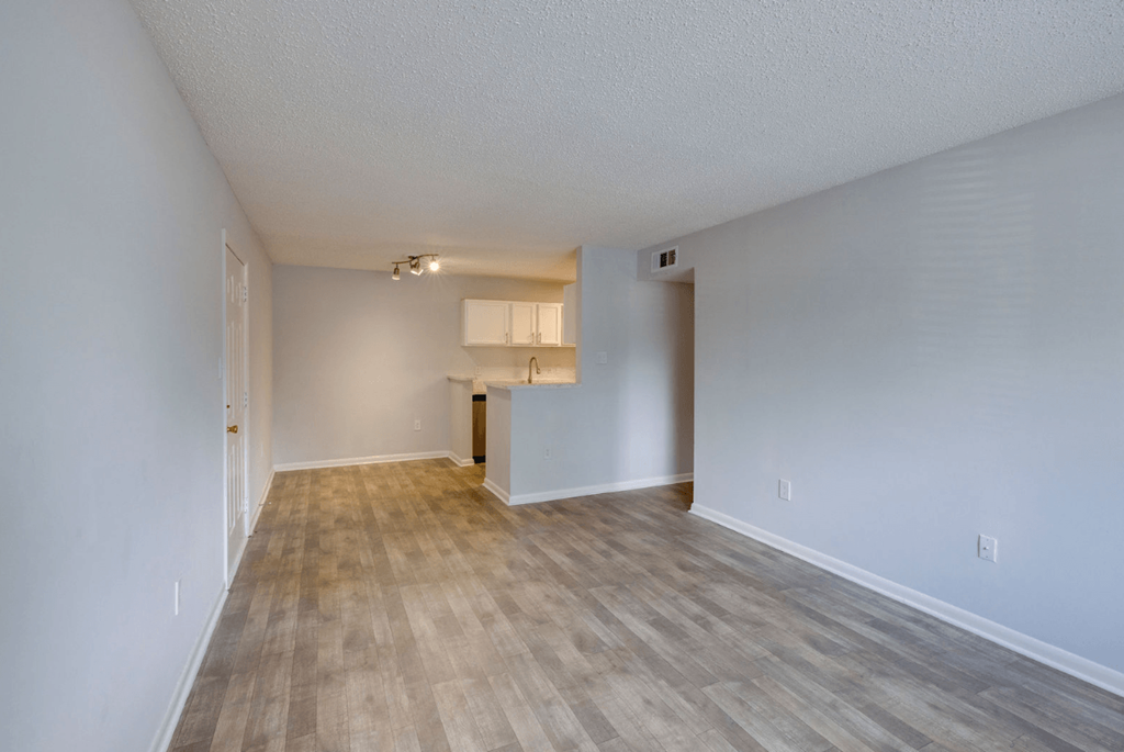 A room with wooden flooring and white walls at Retreat at Savannah Apartments, Savannah, GA