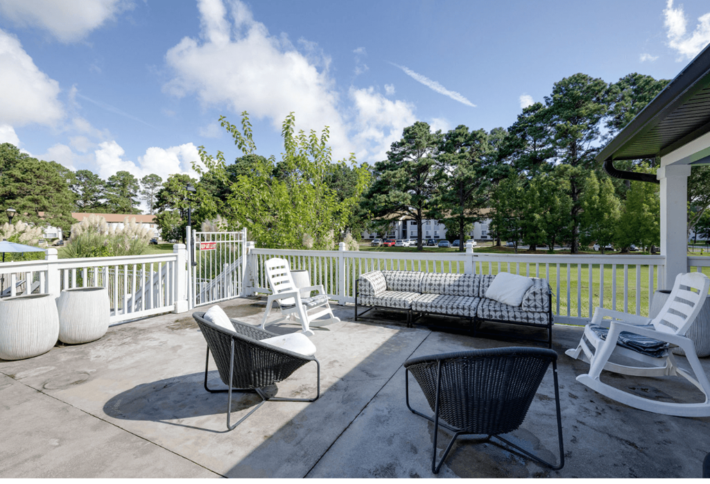 A patio with a white chair and a black chair at Retreat at Savannah Apartments, Savannah