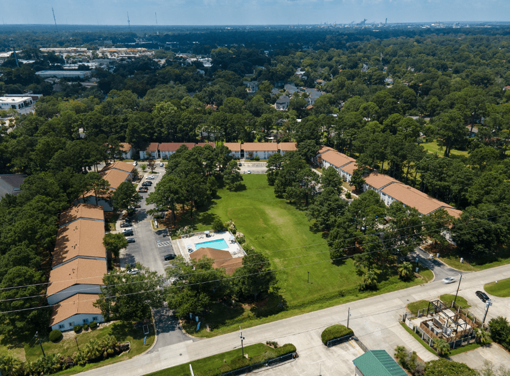 A bird's eye view of a residential area with houses, roads, and a swimming pool at Retreat at Savannah Apartments, Savannah, GA