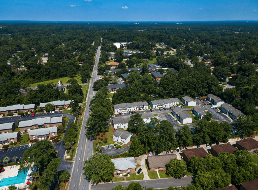 A bird's eye view of a residential area with houses, roads, and trees at Savan Pointe Apartments, Savannah