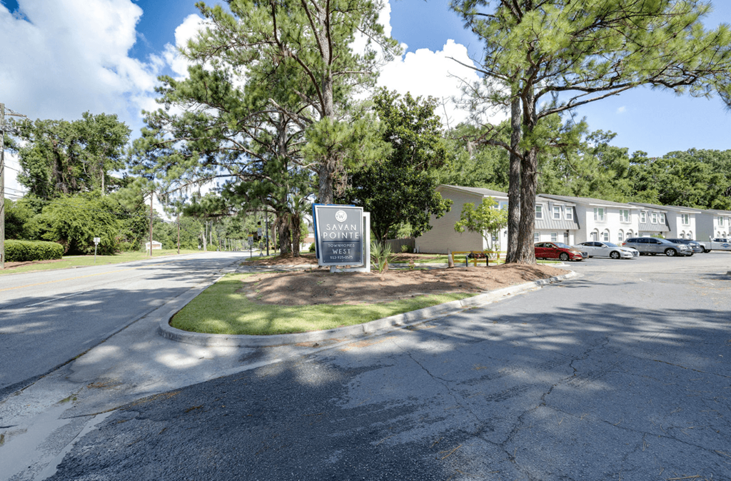 A sign in front of a building with trees around it at Savan Pointe Apartments, Savannah 31406
