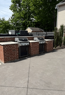 A patio with a BBQ and a grill.