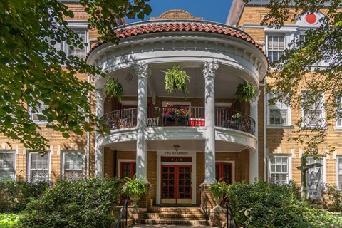 A building with a balcony and a red door.