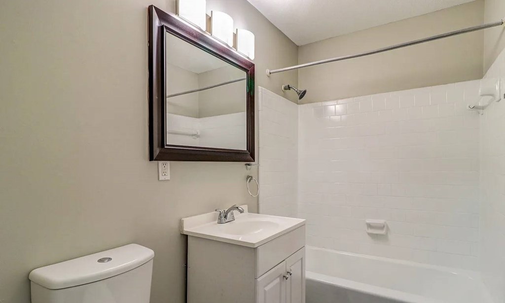 A white toilet sits next to a sink in a small bathroom at Savan Pointe Apartments, Savannah, GA, 31406