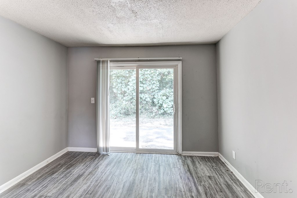 A room with a sliding glass door leading outside.