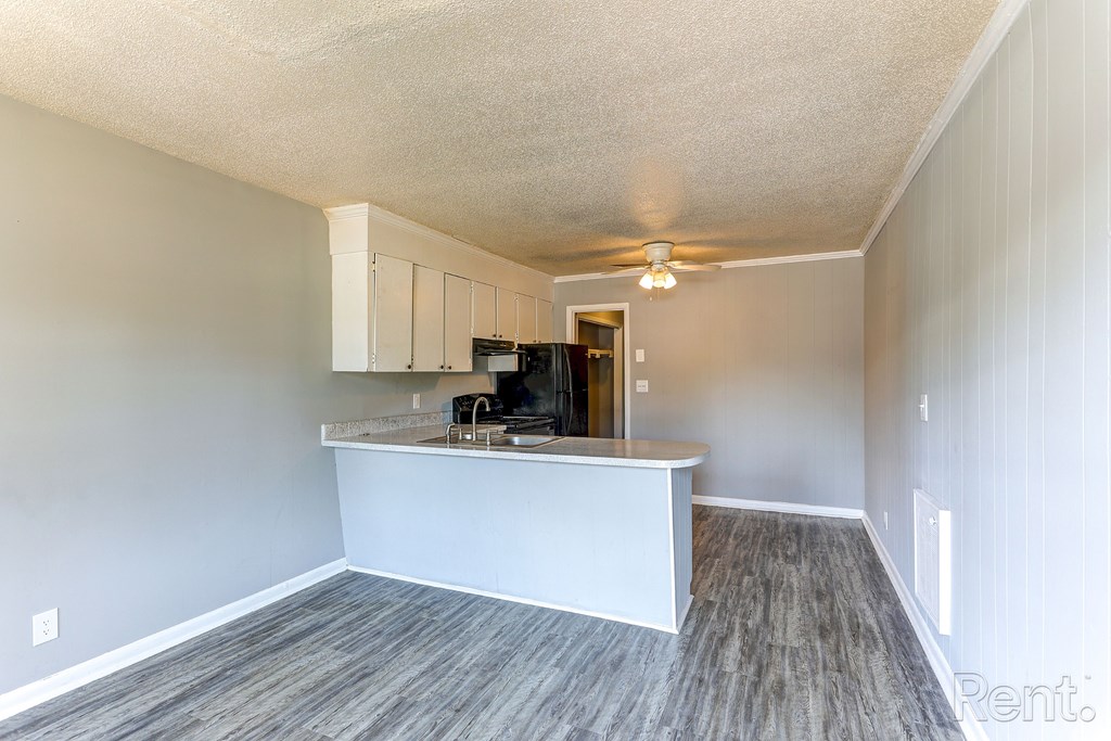 A kitchen area with a counter and white cabinets.