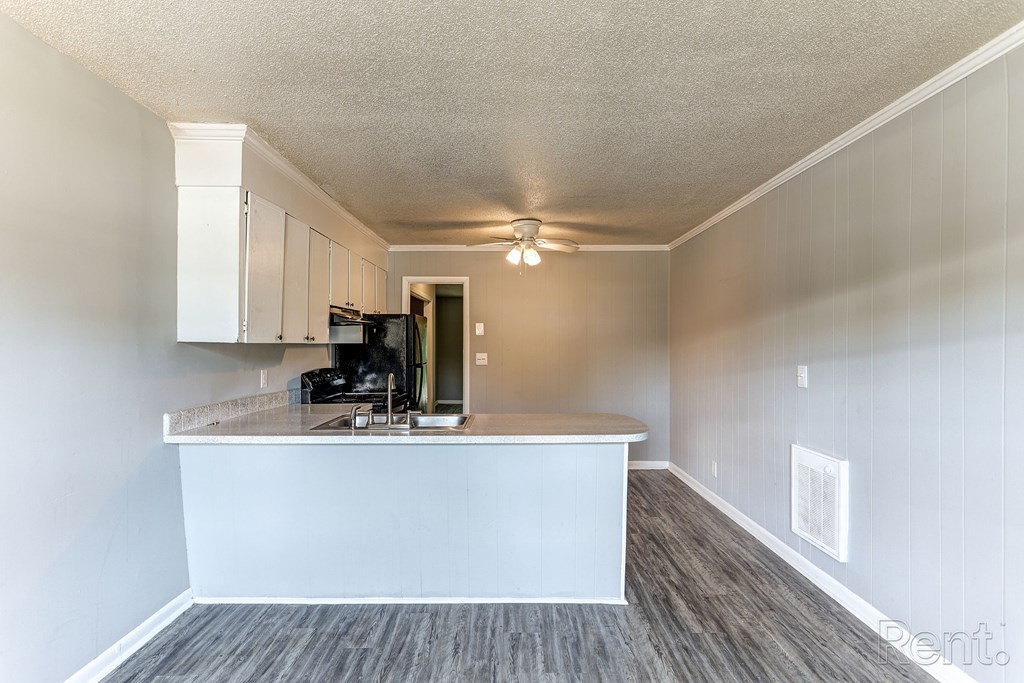A kitchen with a white counter and cabinets.