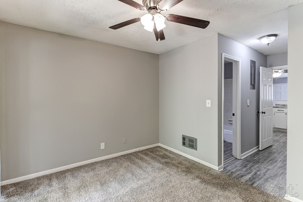 A room with a ceiling fan and a carpeted floor.