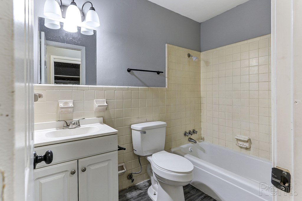 A bathroom with a white toilet, sink, and bathtub.