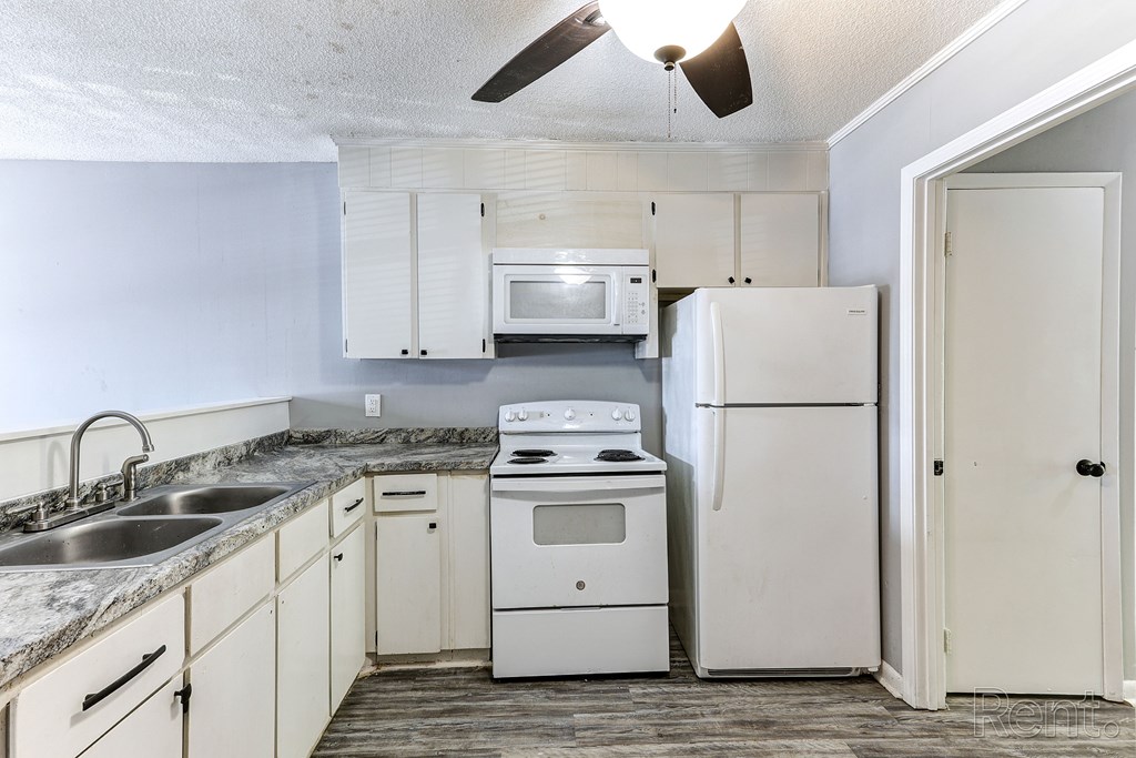 A kitchen with white appliances and cabinets.