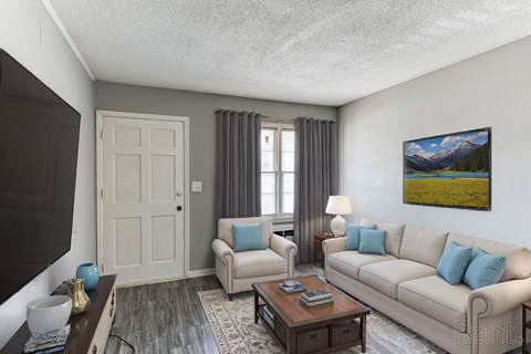 A living room with a couch, a coffee table, and a painting on the wall.