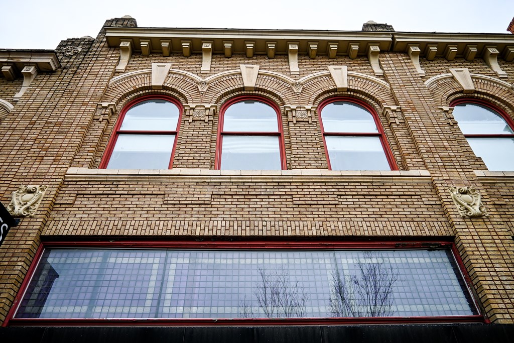 A red brick building with three arched windows.