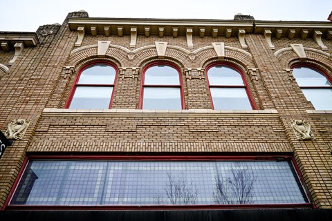 A red brick building with three arched windows.