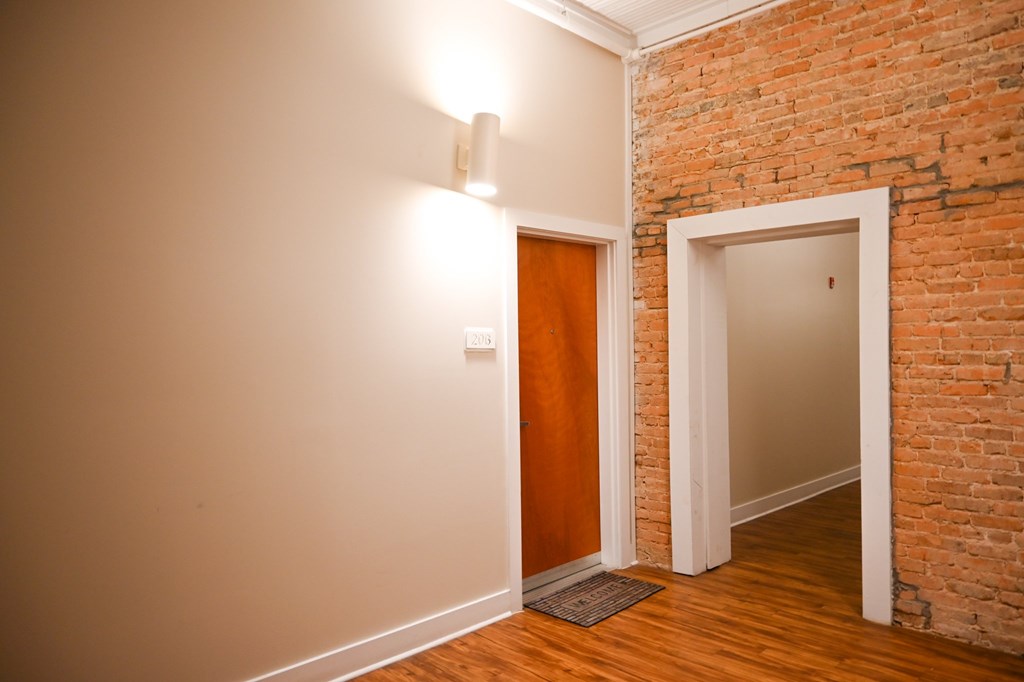 A room with a brick wall and a wooden floor.