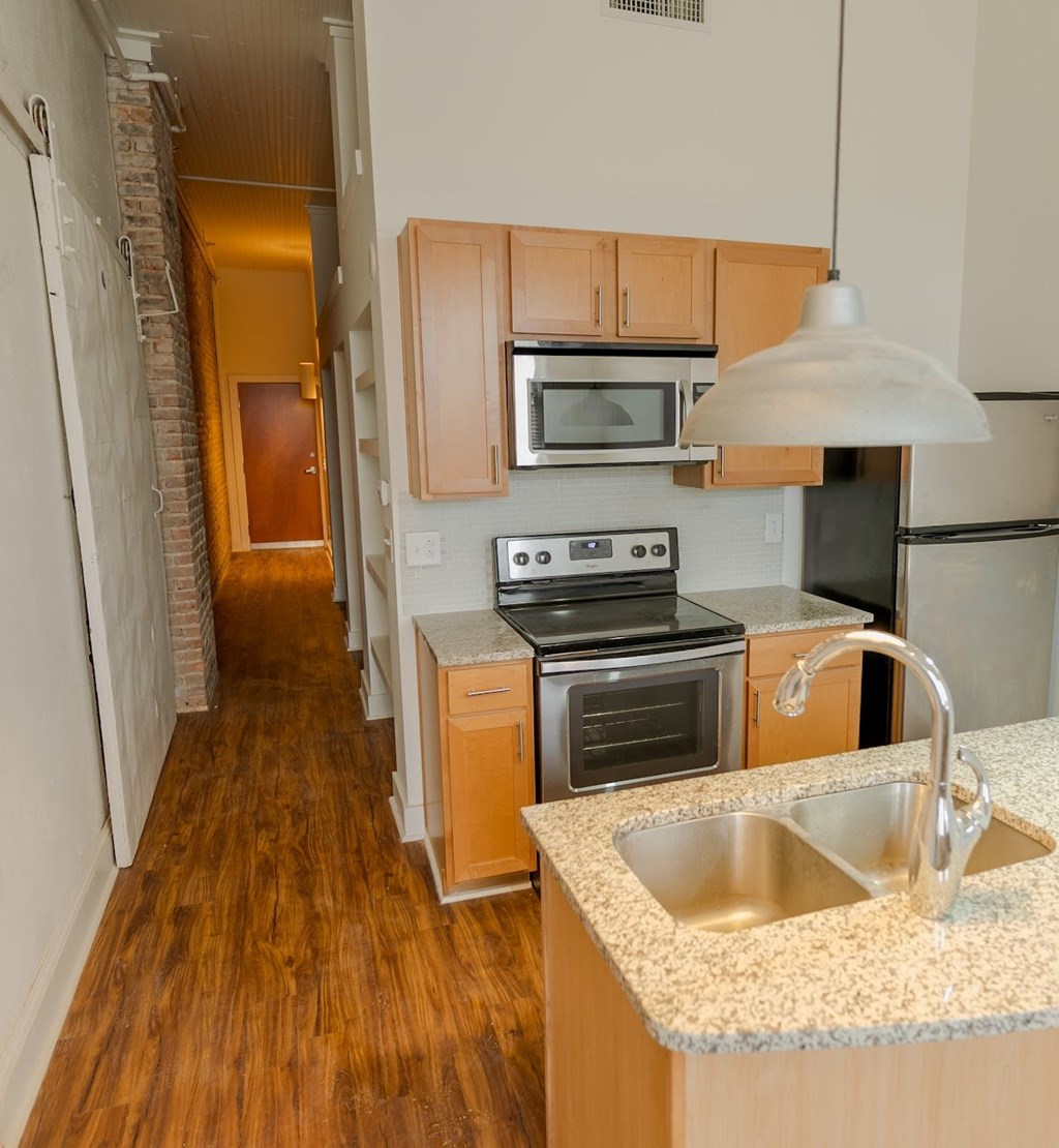 A kitchen with wooden cabinets and a stove top oven.