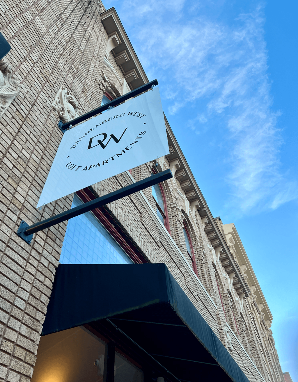 A sign for a vacation rental is hanging from a building.
