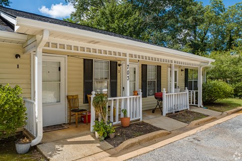 A small house with a porch and a white railing.