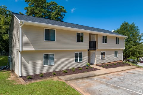 A two-story building with a parking lot in front.
