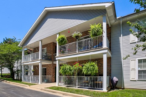 A two-story building with a balcony and a metal railing.