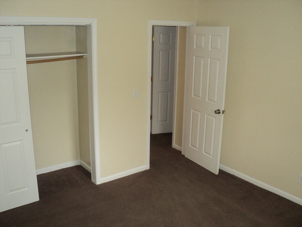 A room with two white doors and a carpeted floor.