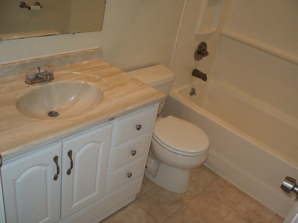 A white toilet sits next to a sink in a bathroom.