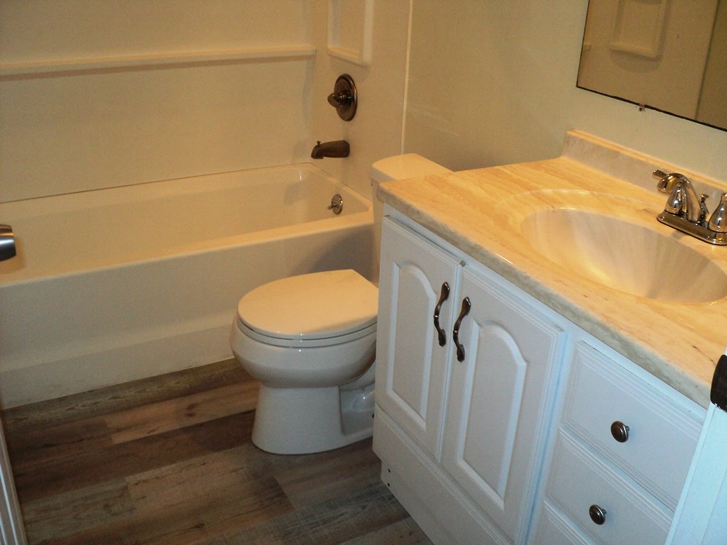 A white toilet sits next to a white sink in a bathroom.