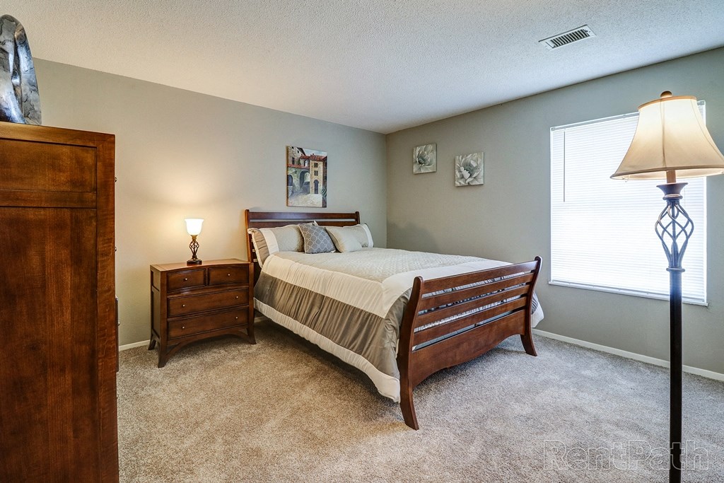 a bedroom with a bed and a dresser and a window