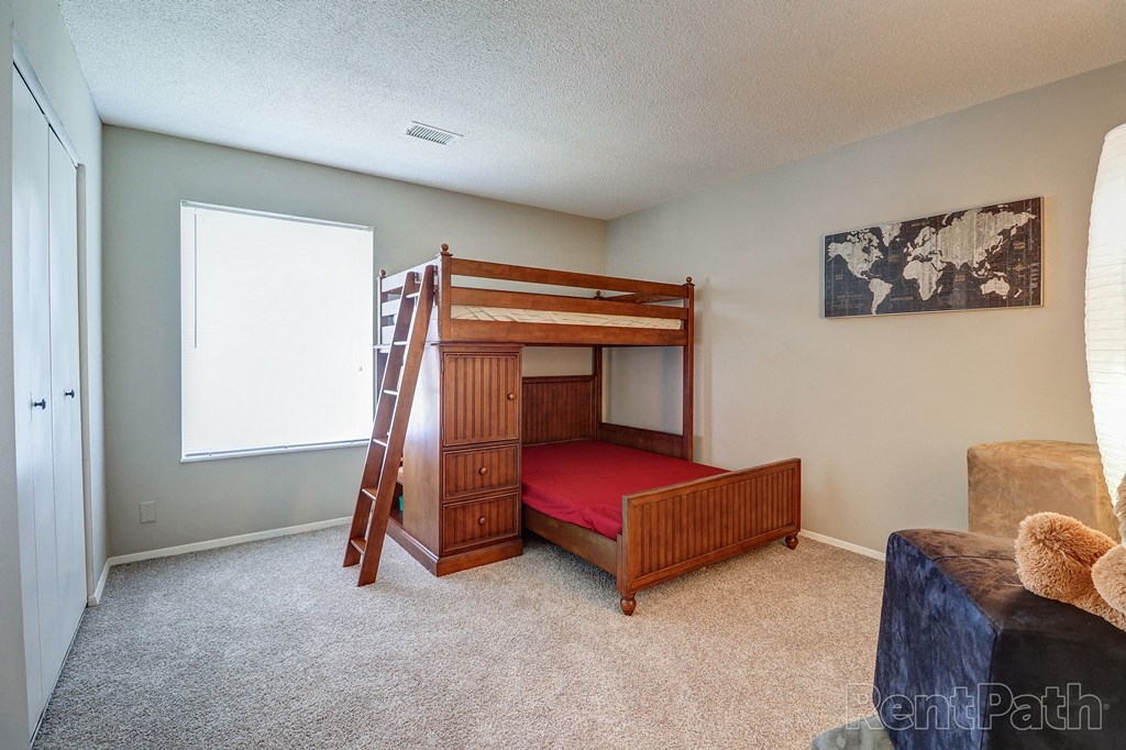 a bunk bed in a room with a couch and a chair