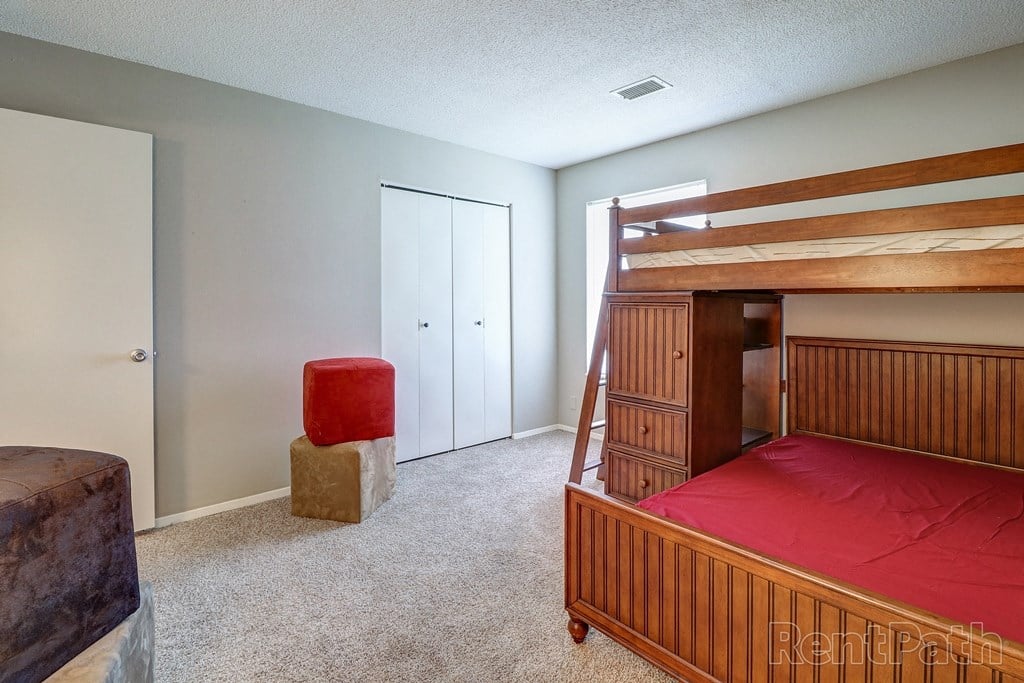 a bunk bed in a bedroom with a couch and a chair