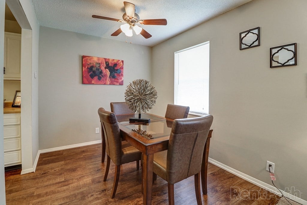 a dining room with a table and chairs and a ceiling fan
