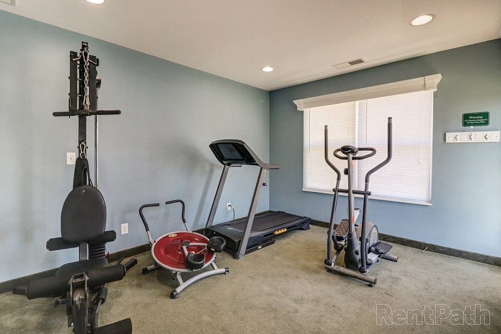 a home gym with exercise equipment and a window