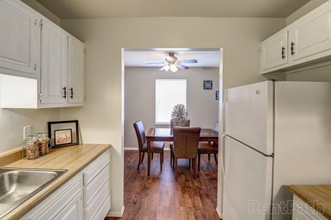a kitchen with white cabinets and a dining room with a table
