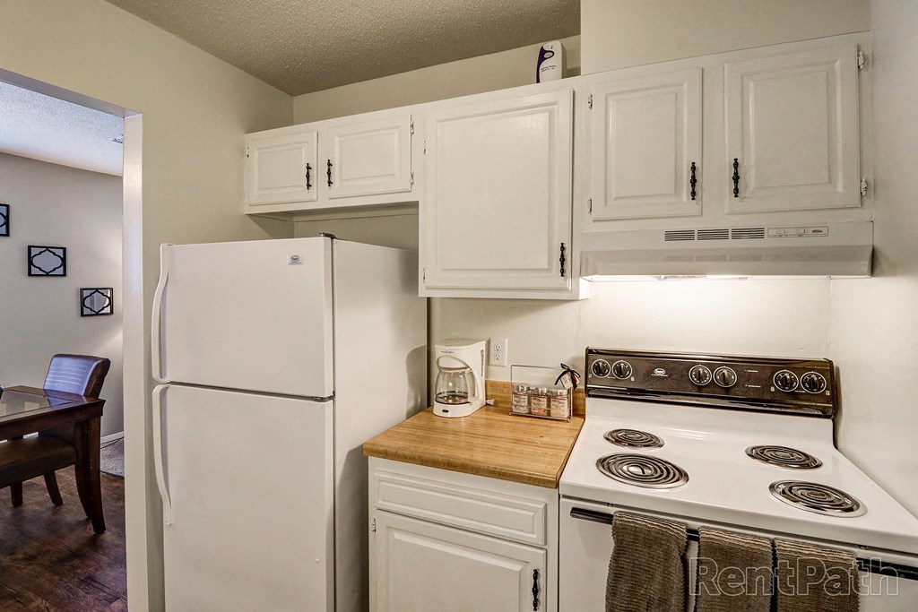 a kitchen with white cabinets and a stove and a refrigerator