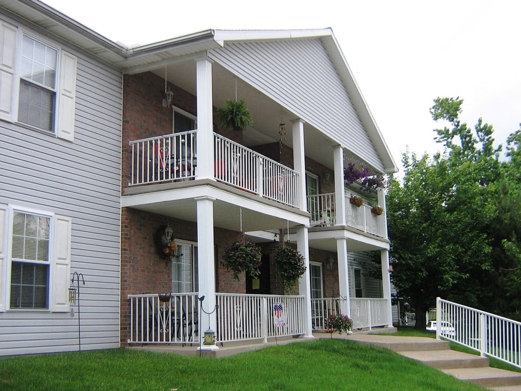 the front of a house with a porch and a lawn