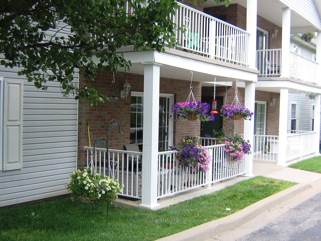 a house with a white porch with flowers on it