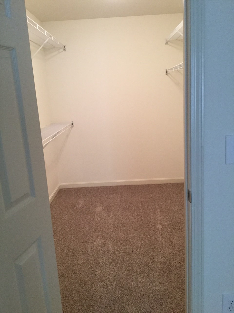 a room with a closet and two shelves in it