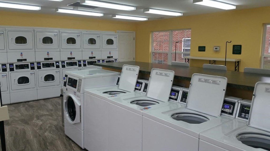 a group of washing machines and dryers in a laundromat