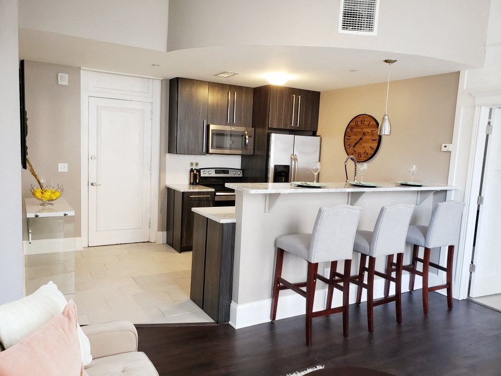 a view of a kitchen with a bar and a living room