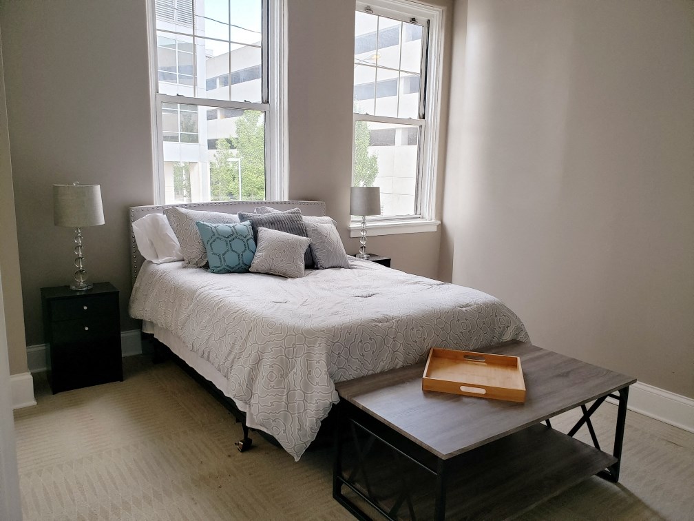 a small bedroom with a bed and a coffee table